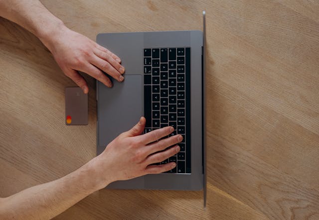 Person using a credit card and laptop to make an online payment